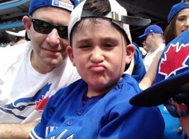 Michael Back, founder of HONK, poses with his son at a sporting event.