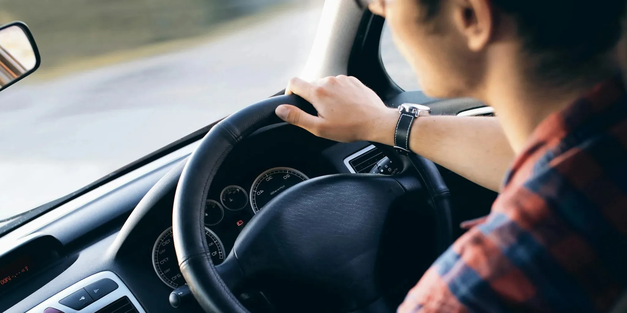 A close-up of a man driving a car.