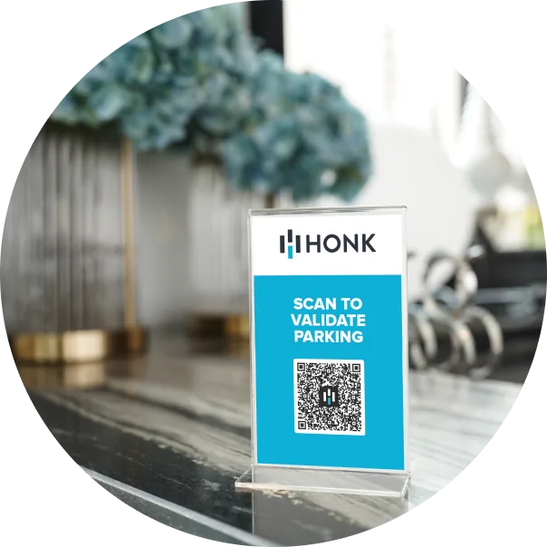 A small table sign with the HONK logo at the top and a QR code below, displaying the text 'SCAN TO VALIDATE PARKING' in a blue box.